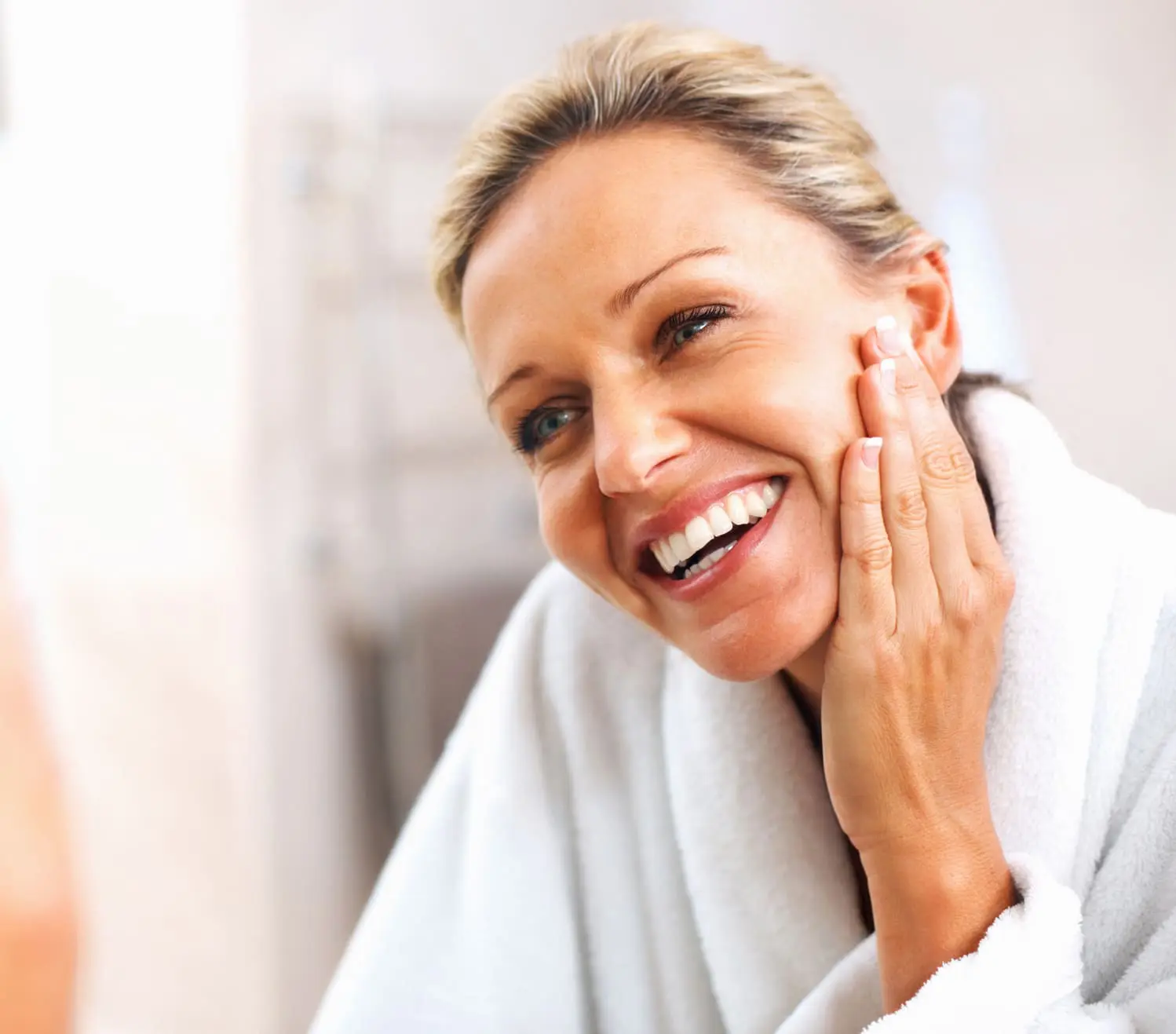 Happy mature woman admiring herself in the mirror Non-Surgical Skin Tightening in Charleston County, SC